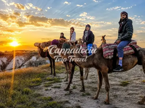 Cavalieri sui cammelli tra i camini delle fate in Cappadocia