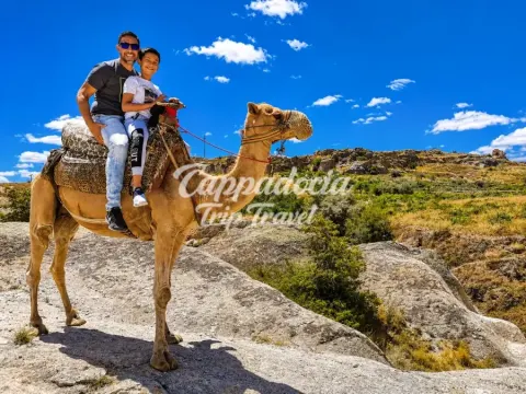 Turisti in giro sul cammello tra i paesaggi rocciosi della Cappadocia