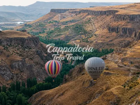 Belon berwarna-warni melayang di atas batuan Lembah Soğanlı, Cappadocia